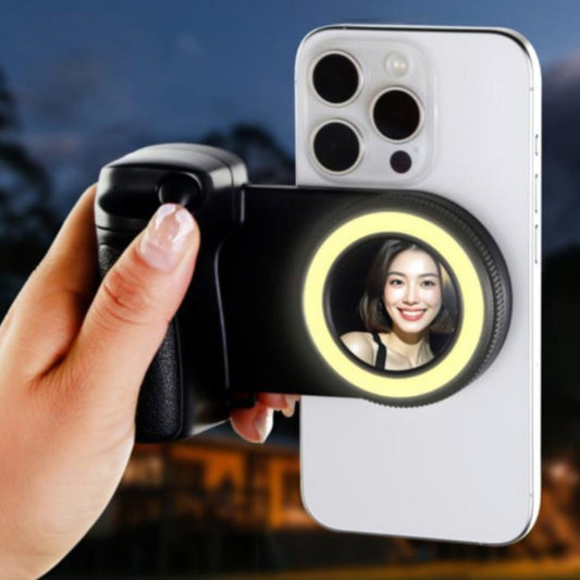 Smartphone with a ring light attachment held by a hand against a blurred background