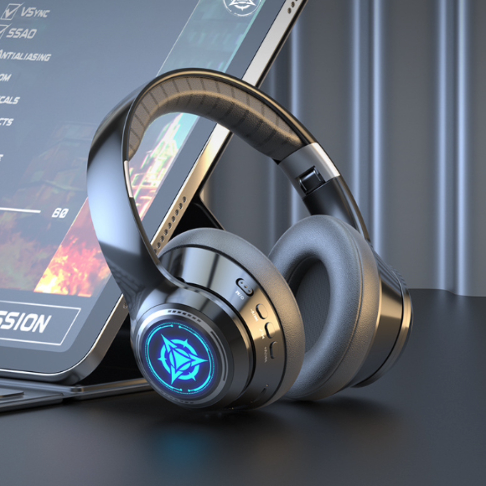 High-end headphones with a futuristic design on a dark surface, with a blurred gaming console in the background.