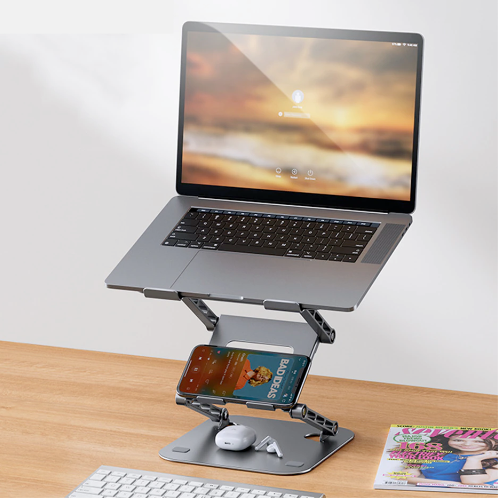 Laptop on a stand with a smartphone and other items on a desk