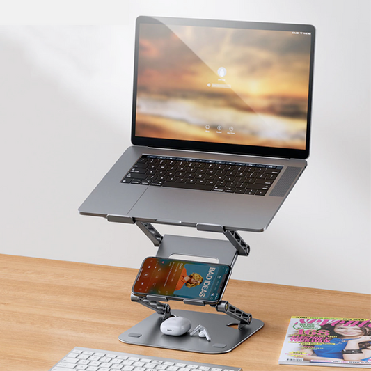 Laptop on a stand with a smartphone and other items on a desk